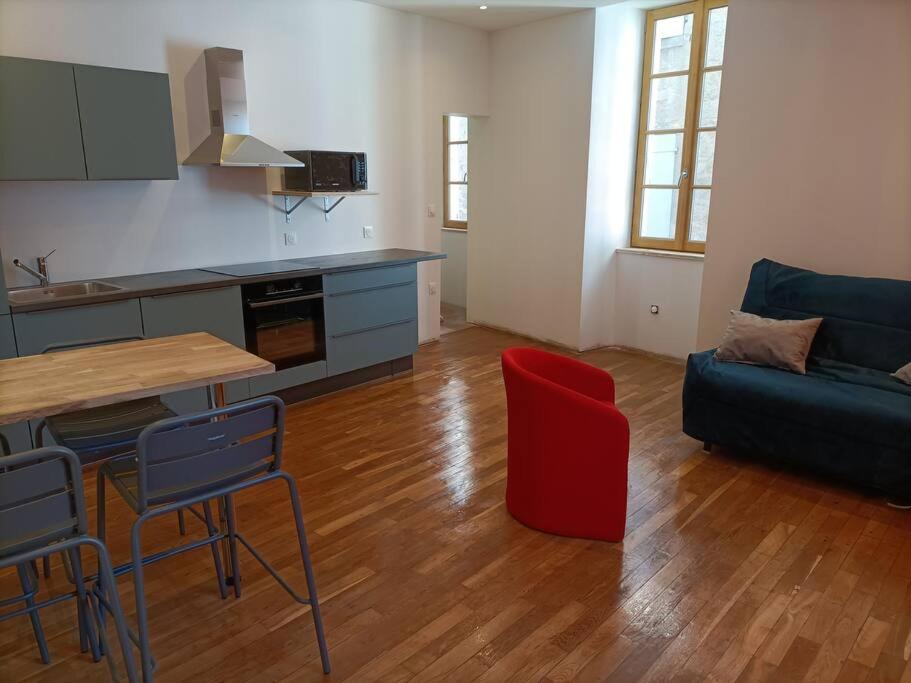 eine Küche und ein Wohnzimmer mit einem Tisch und einem Sofa in der Unterkunft Appartement 1er étage in Largentière