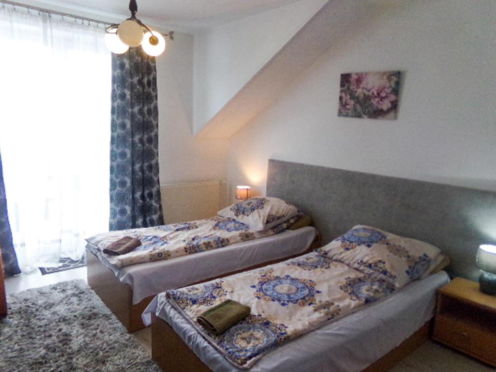 a bedroom with two beds and a window at Motel Anna Serafin in Radom