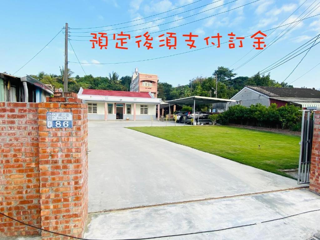 a driveway with a brick wall and a house at 關廟 86民宿 包棟 