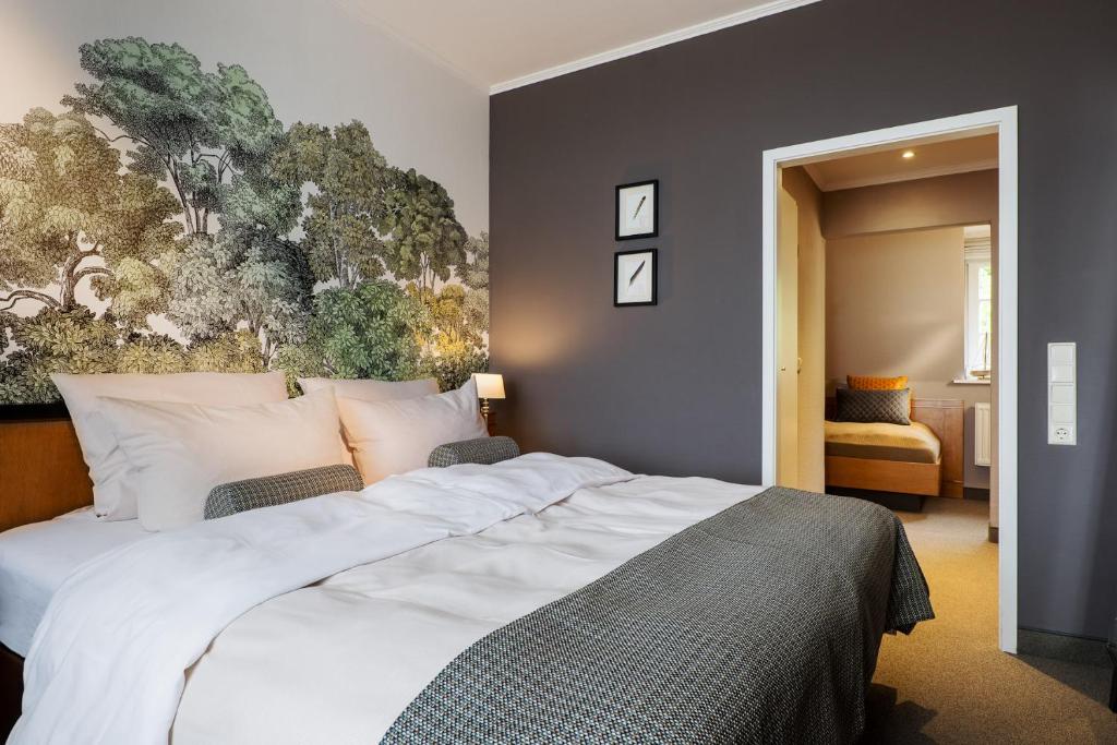 1 dormitorio con 1 cama grande y una pintura en la pared en Hotel Wassersleben, en Flensburg
