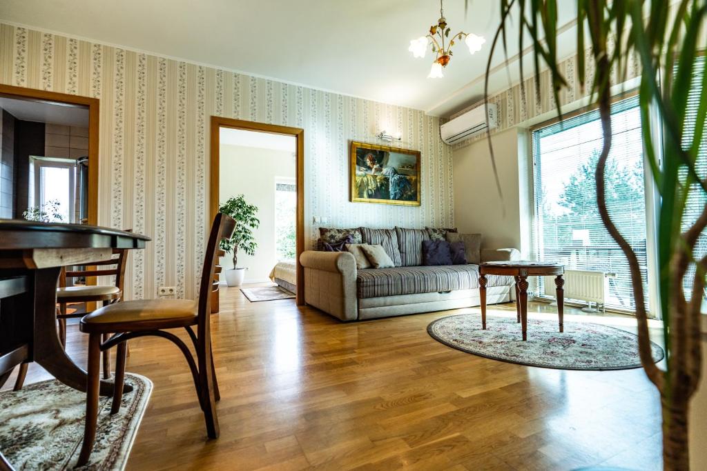 a living room with a couch and a table at Ramaus Poilsio Apartamentai in Palanga