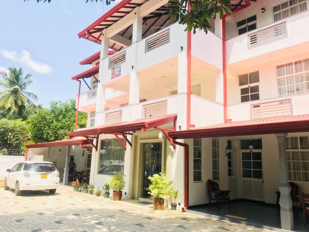 un coche blanco estacionado frente a un edificio en Hotel Ganthera Kataragama, en Kataragama