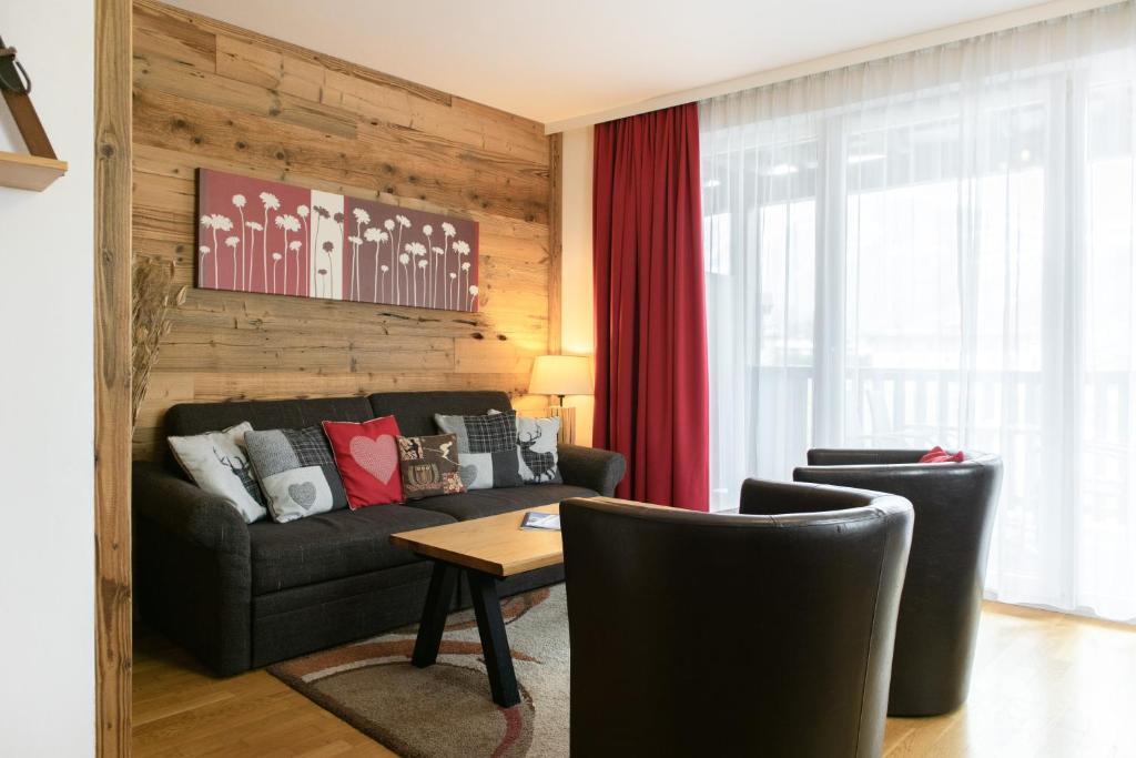 ein Wohnzimmer mit einem Sofa und einem Tisch in der Unterkunft Apartment Adler Resort by Alpin Rentals in Kaprun