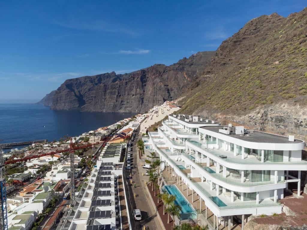 a group of white buildings on the side of a mountain at Crystal I Luxury Apartments by EnjoyaHome in Santiago del Teide