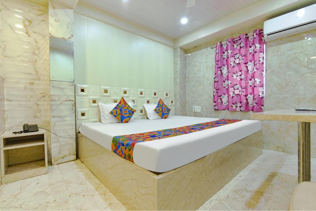 a bedroom with a bed and a pink curtain at Comfort Place in Salua