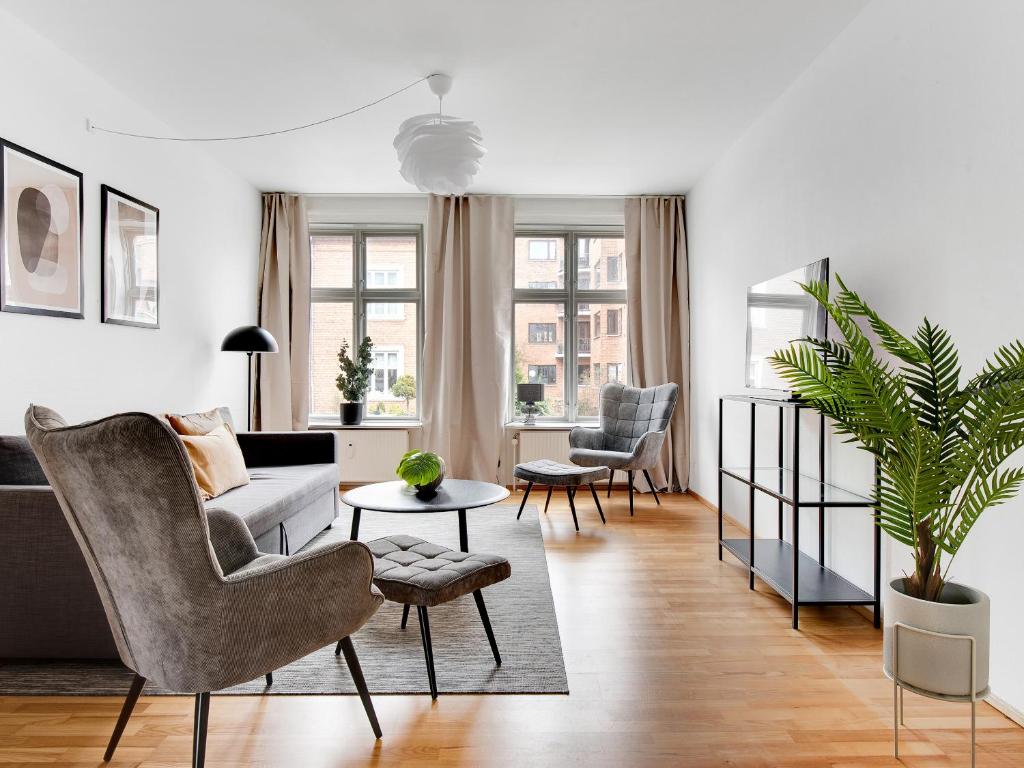 ein Wohnzimmer mit einem Sofa und einem Tisch in der Unterkunft Sanders Constantin - Chic Two-Bedroom Apartment With Balcony in Kopenhagen