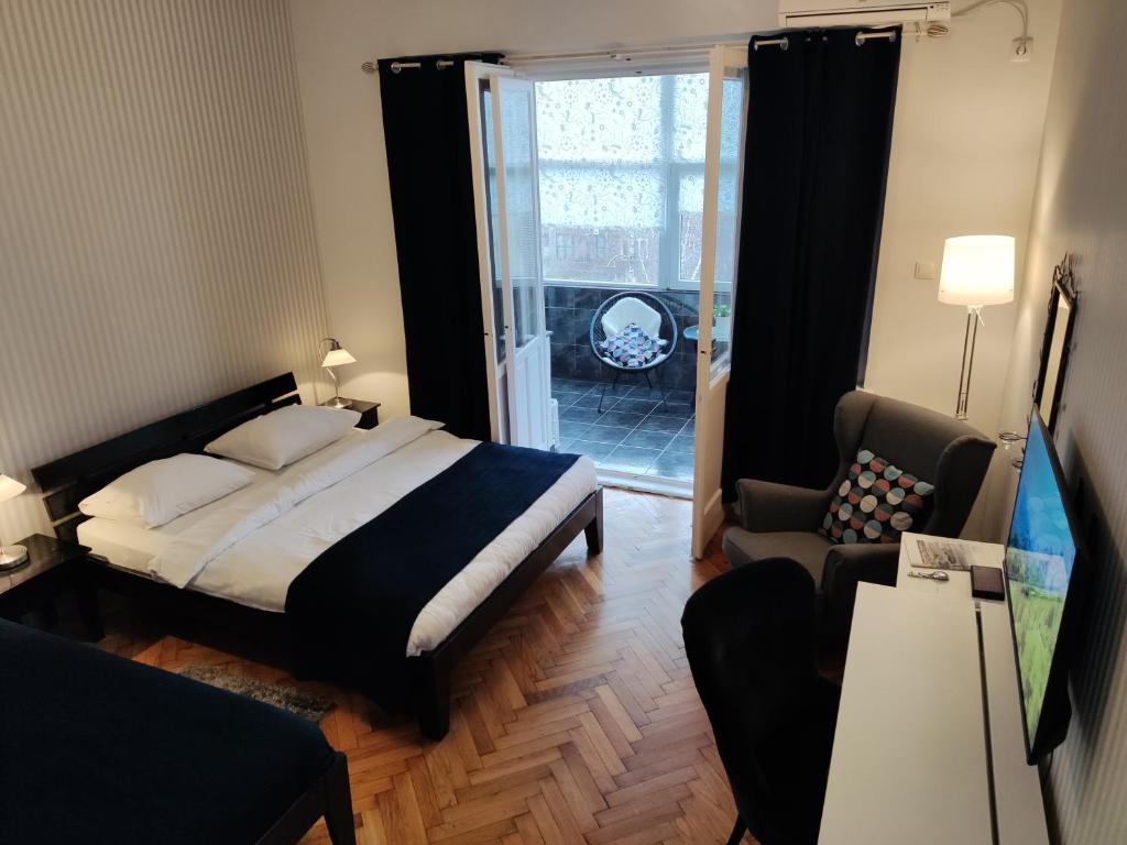um quarto com uma cama e uma sala de estar em Selection Rooms em Belgrado