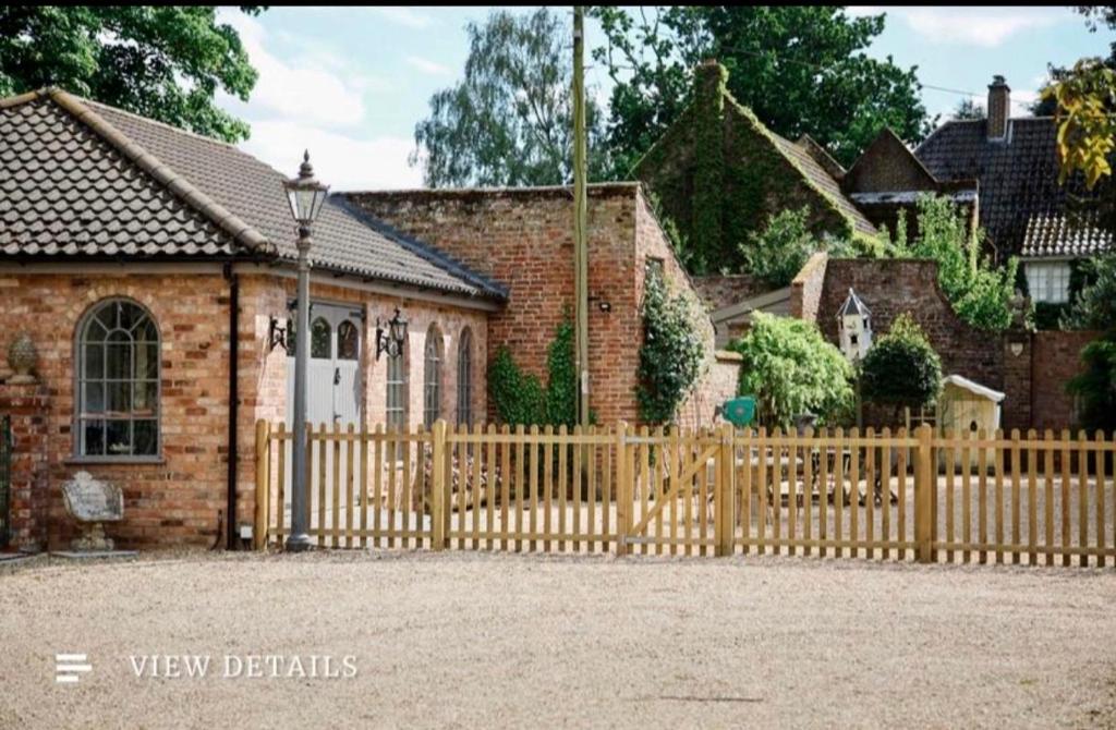 a wooden fence in front of a house at The Dairy in Sutterton