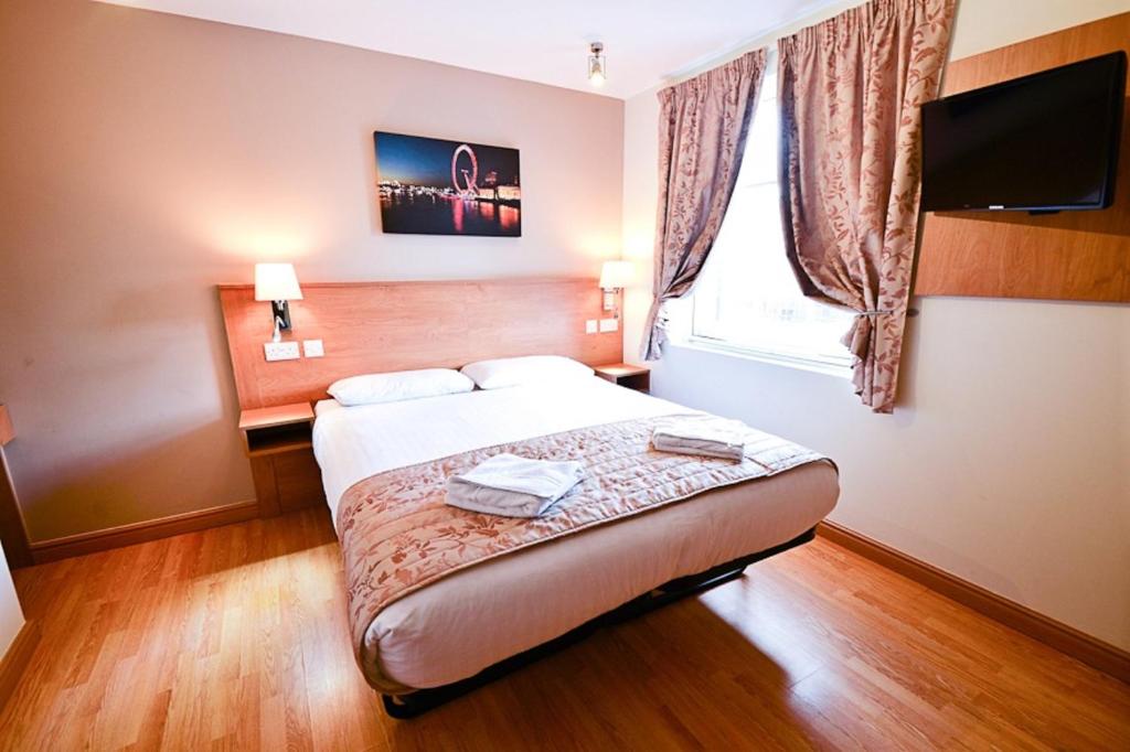 a hotel room with a bed and a window at Kings Cross Inn Hotel in London