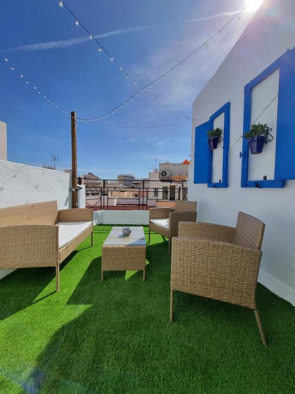 eine Terrasse mit Stühlen, einem Tisch und Gras in der Unterkunft Terraza Almería in Almería
