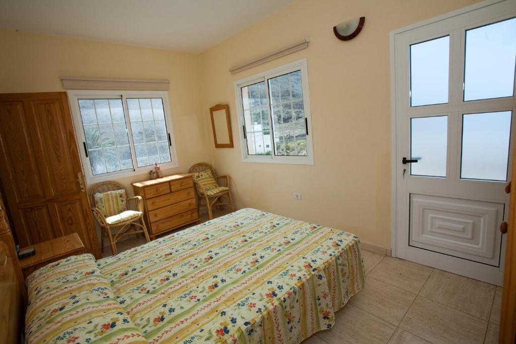 Un dormitorio con una cama, una cómoda y ventanas. en Apartamentos Arure Plaza, en Arure