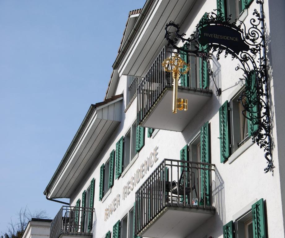 um edifício com persianas verdes e um relógio em River Residence em Baden