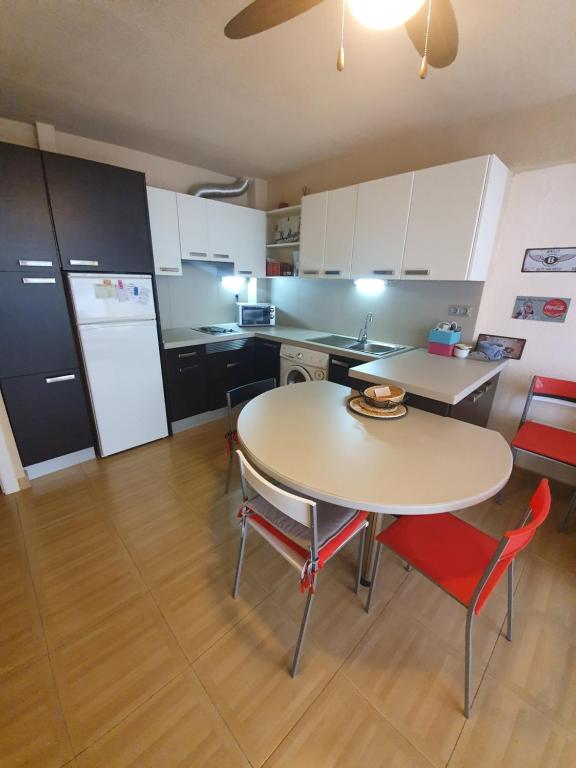 cocina con mesa, sillas y nevera en Apartament in Benidorm Downtown, en Benidorm