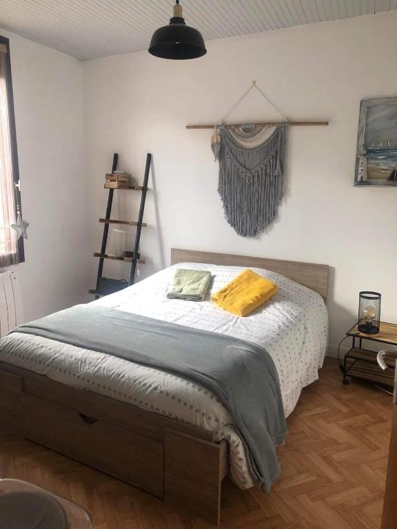 une chambre avec un lit avec une couverture jaune dessus dans l'établissement La Parenthèse - maison Tréportaise avec cour fermée, au Tréport