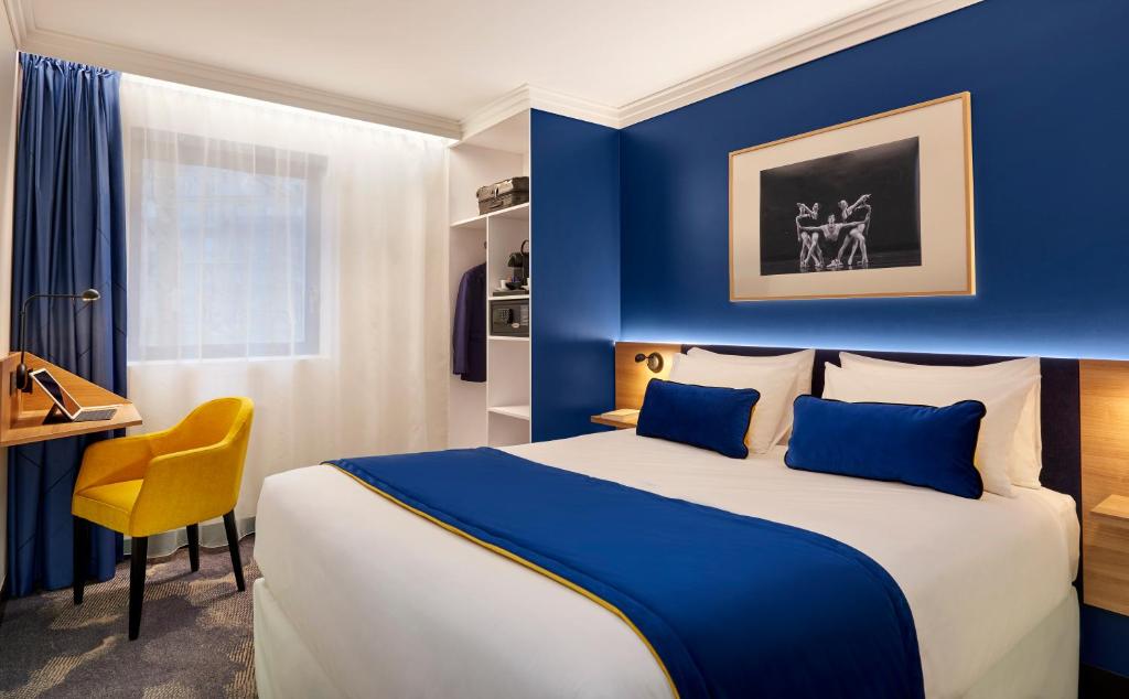 Cette chambre comprend un grand lit et un bureau. dans l'établissement B&B HOTEL Paris 17 Batignolles, à Paris