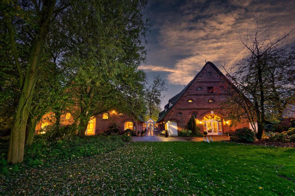 een groot huis met lichten aan in een tuin bij Hotel Gut Schöneworth in Freiburg - Elbe