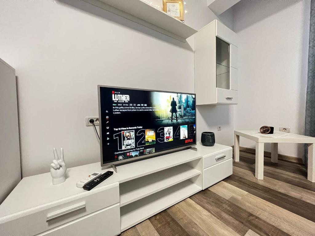 un soggiorno con una grande TV a schermo piatto di Cozy Deluxe Apartments in Centre of Historical Suceava a Suceava