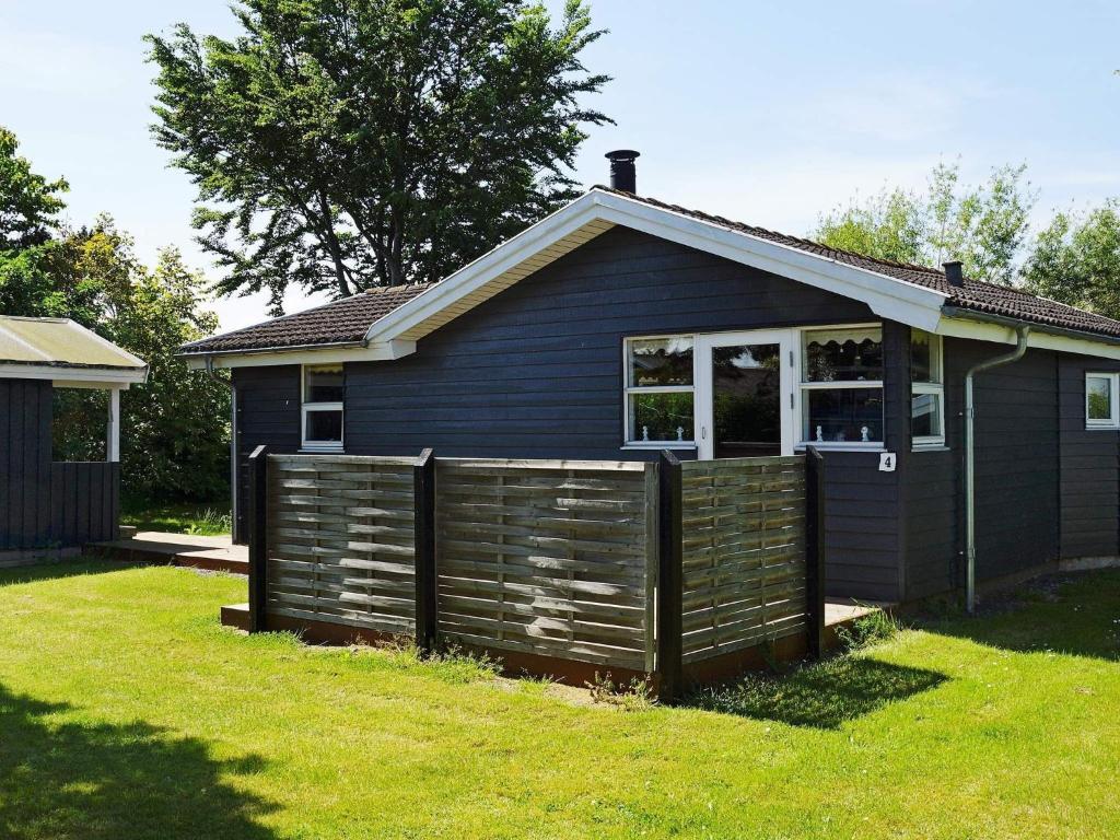 ein blaues Haus mit einem Zaun davor in der Unterkunft 8 person holiday home in Hesselager in Hesselager