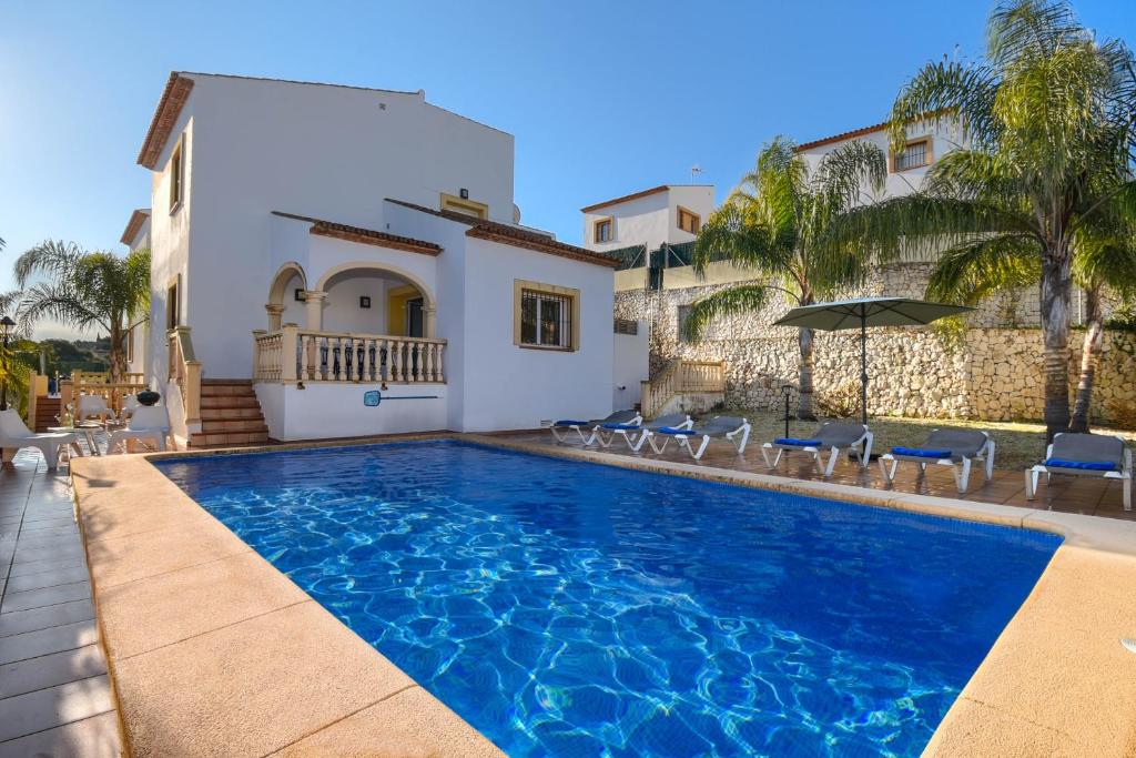 a swimming pool in front of a villa at Monte Blanco in Jávea