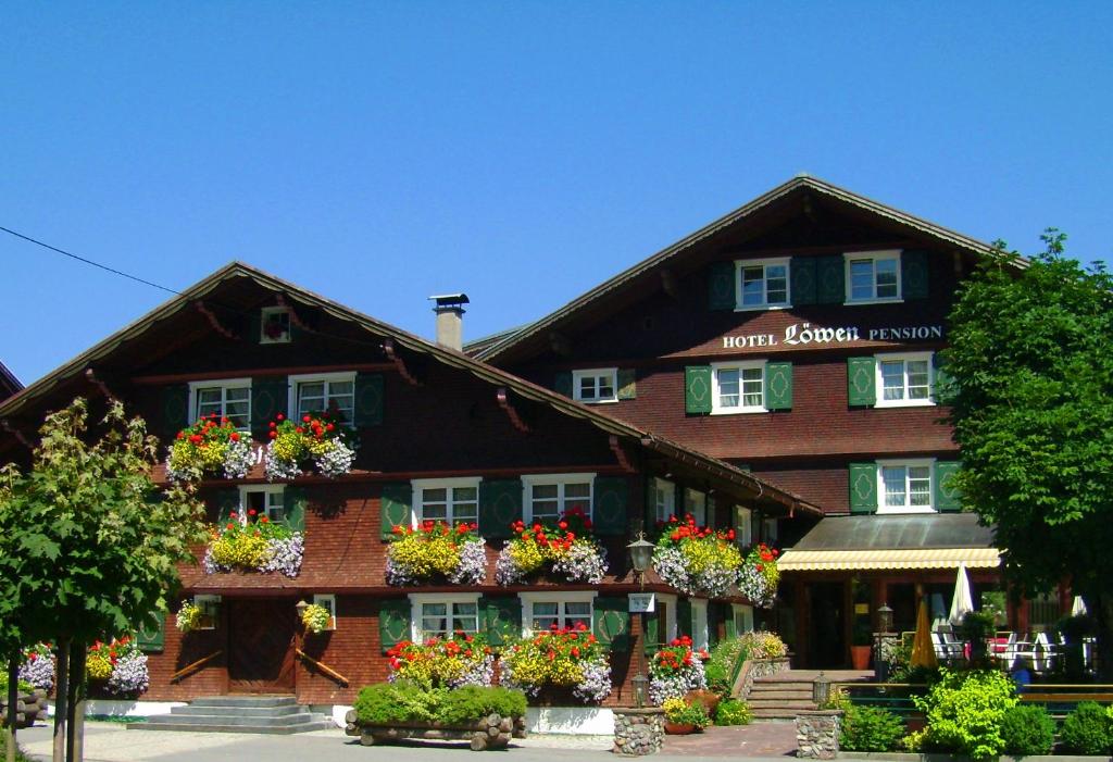 a building with flower boxes on the front of it at Schedlers Löwenhotel-GARNI in Alberschwende