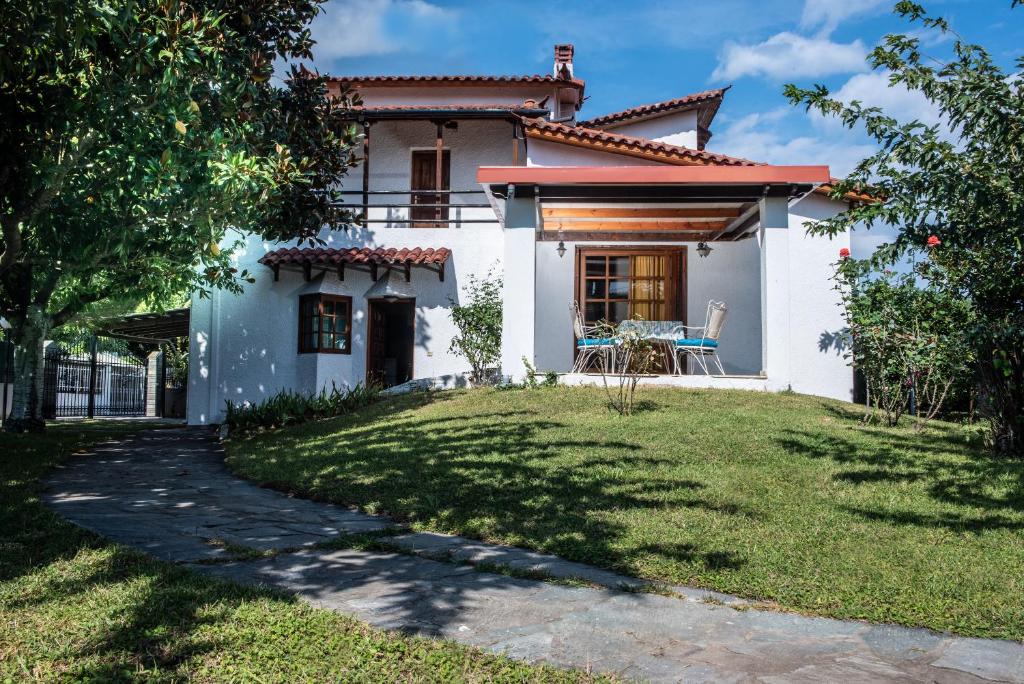 卡梅納維洛拉的住宿－Villa Kontos，前面有草坪的白色房子