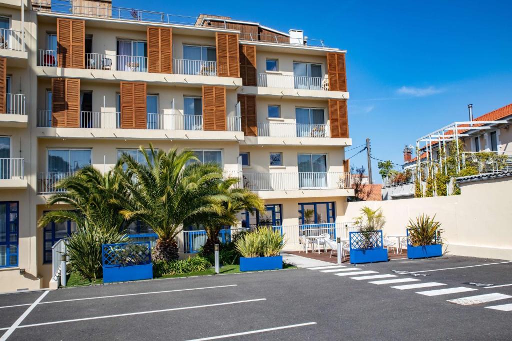 un estacionamiento frente a un edificio en Best Western Arcachon Le Port en Arcachón