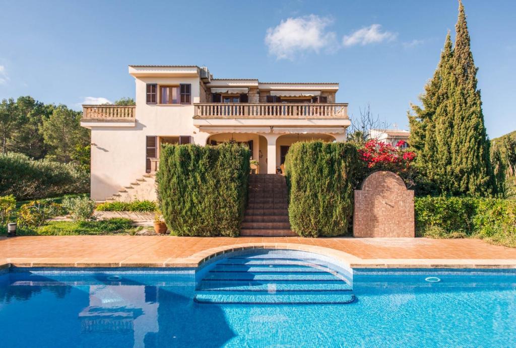 a house with a swimming pool in front of a house at Finca Ceguer MHM in Font de Sa Cala