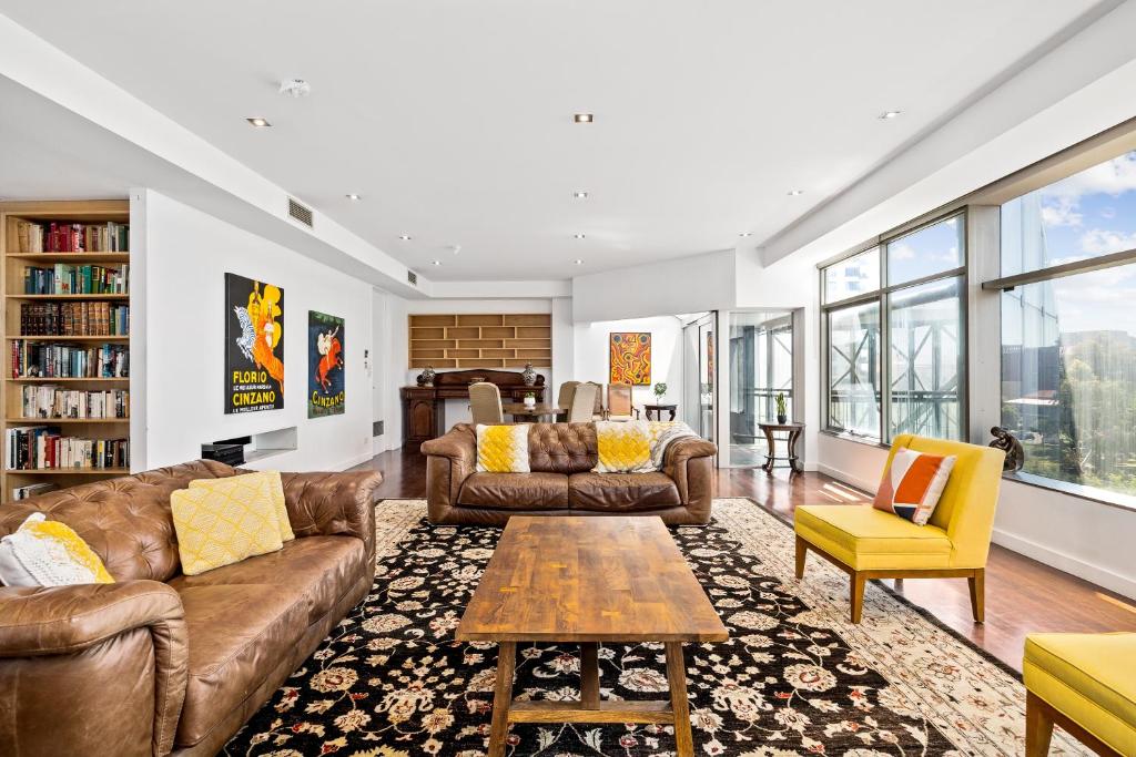 a living room with couches and a coffee table at Swainson on Waymouth - Penthouse in Adelaide