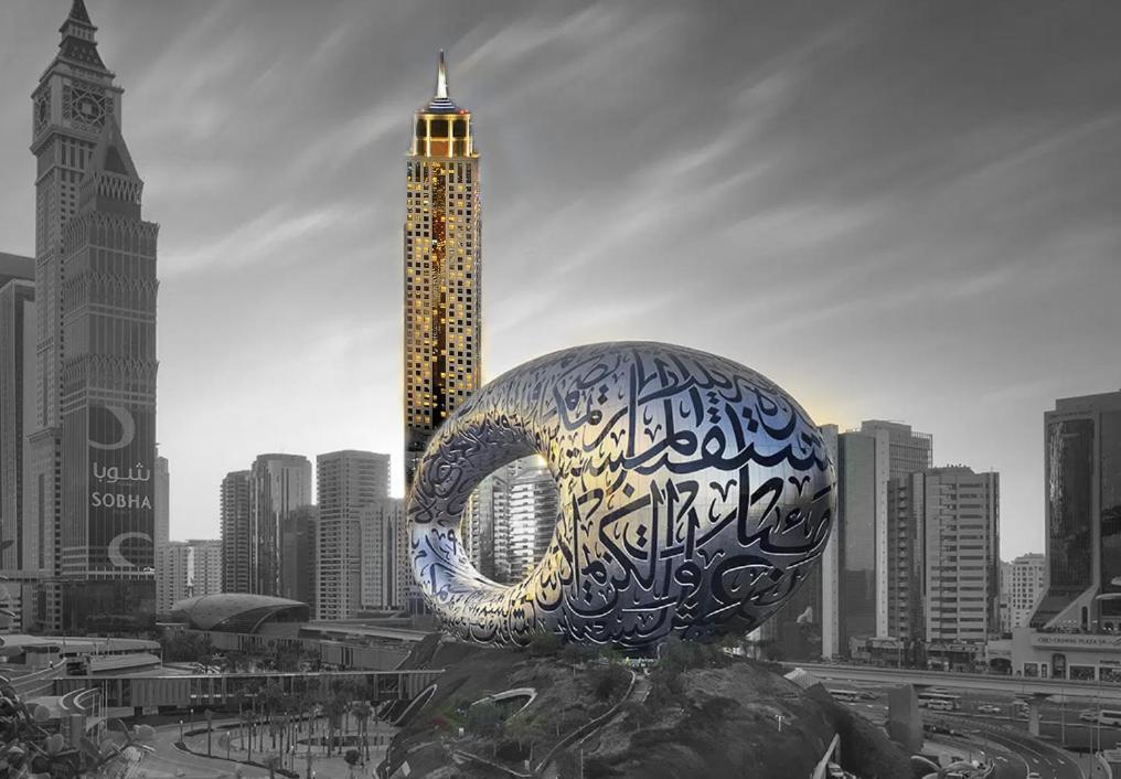 a sculpture with writing on it in front of a city at The Tower Plaza Hotel Dubai in Dubai