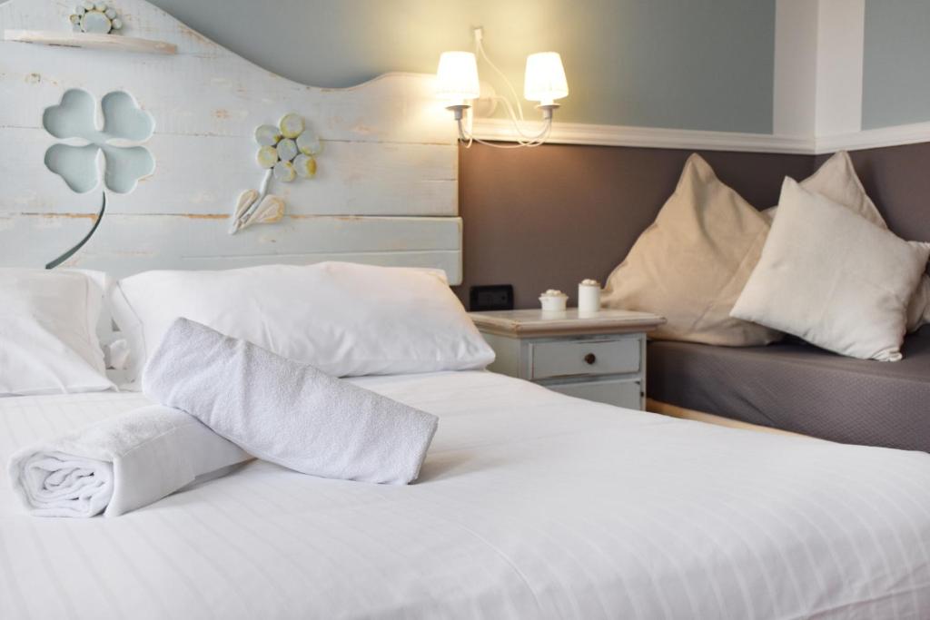 a bedroom with a white bed with white pillows at Venicegreen Agriresort in Tessera