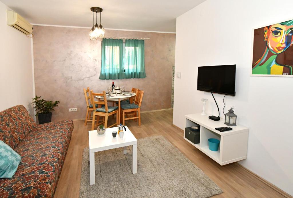 Apartment Welcome في Karaburma: غرفة معيشة مع أريكة وطاولة