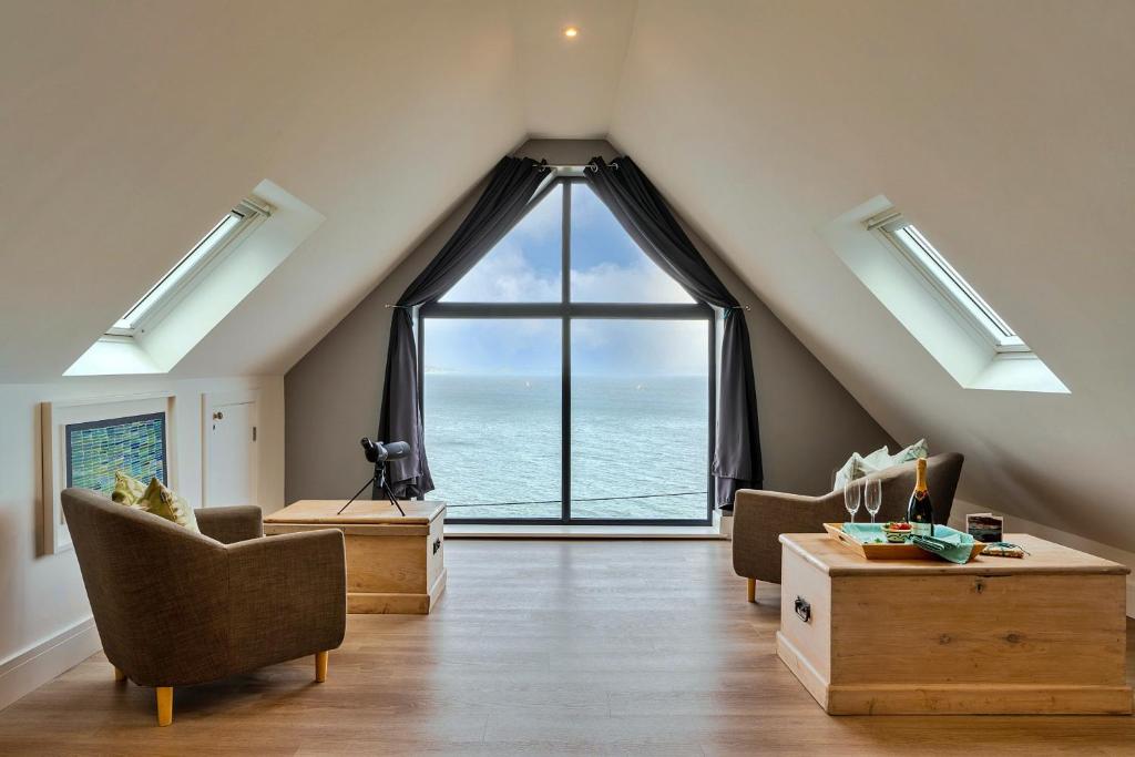 a living room with a large window with the ocean at Finest Retreats - Blue Seas in Mousehole