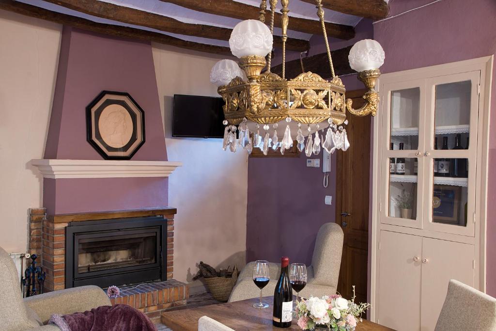 a dining room with a chandelier and a fireplace at La Caseta del Priorat in Porrera