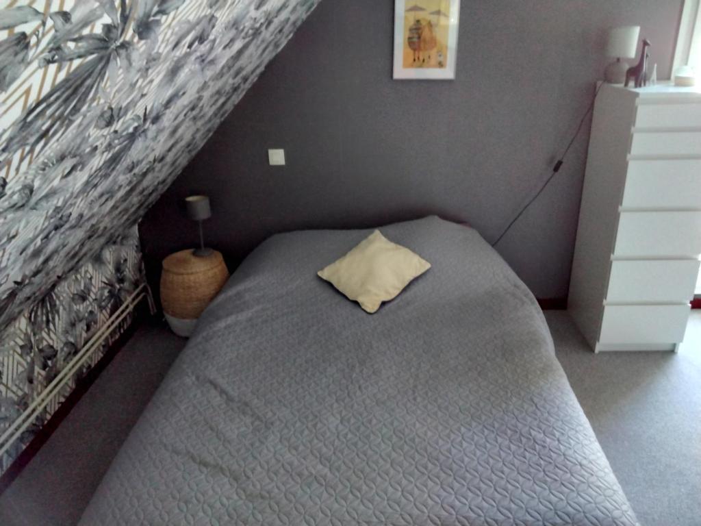 a bedroom with a bed with a pillow on it at La petite mouette in Ouistreham