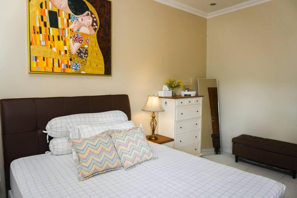 1 dormitorio con 1 cama y una pintura en la pared en Amarillo Lembang en Lembang