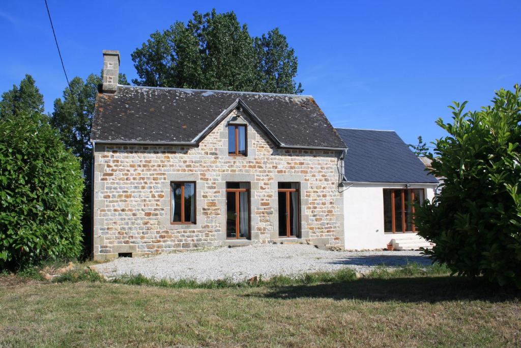 a small stone house with a black roof at L'Aide Frechu in Mortain