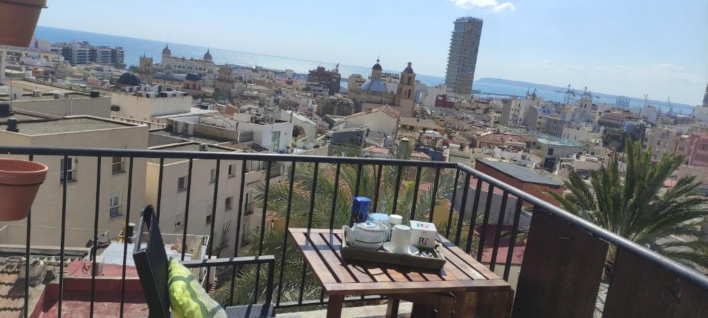 een bankje op een balkon met uitzicht op de stad bij Charming house in the historic old town in Alicante