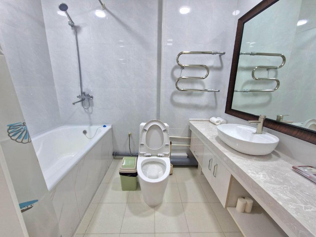 a white bathroom with a toilet and a sink at Copper hotel Erdenet city Mongolia in Erdenet
