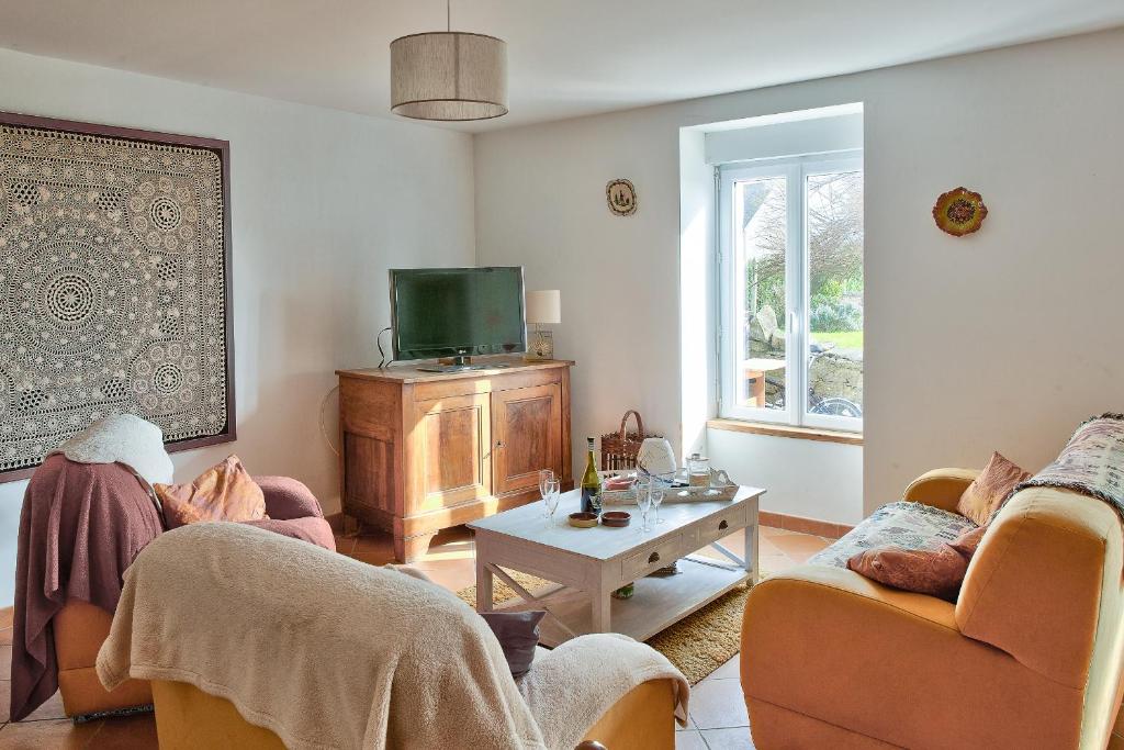 un salon avec deux canapés et une télévision dans l'établissement Maison face à l'océan avec vue mer à Penmarc'h, à Penmarcʼh