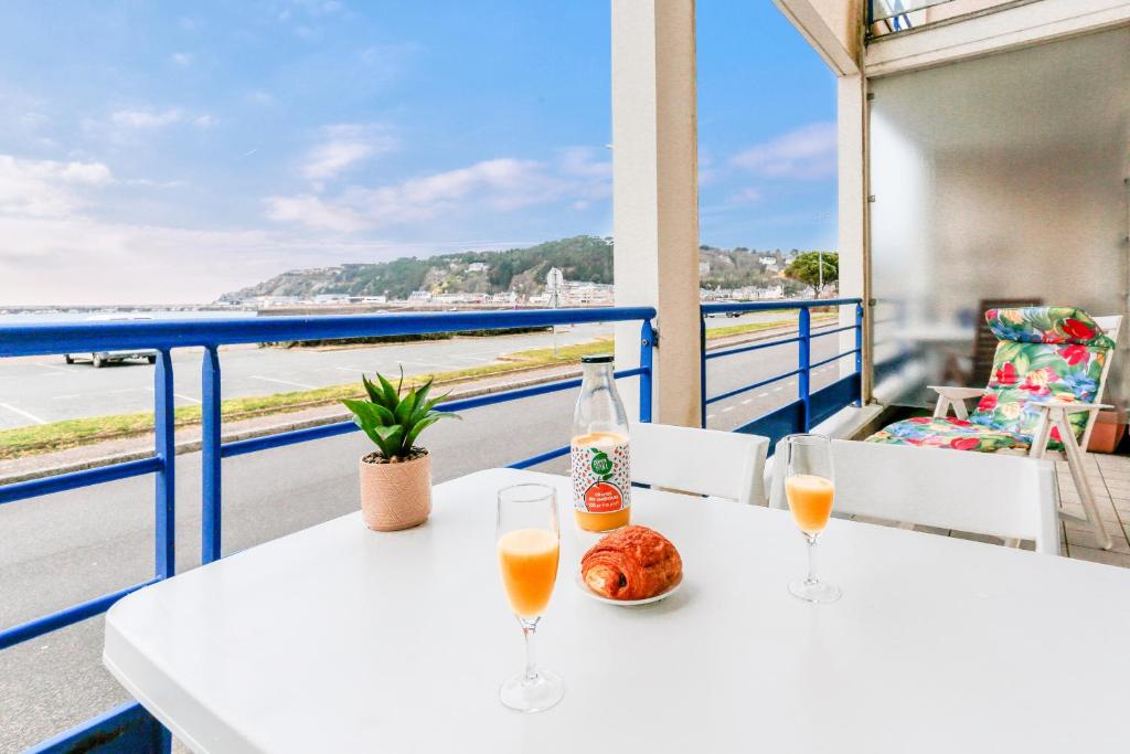 - une table avec deux verres et un bol de jus d'orange dans l'établissement Appartement a moins de 100m de la plage du Bourg pour 4 personnes, à Erquy