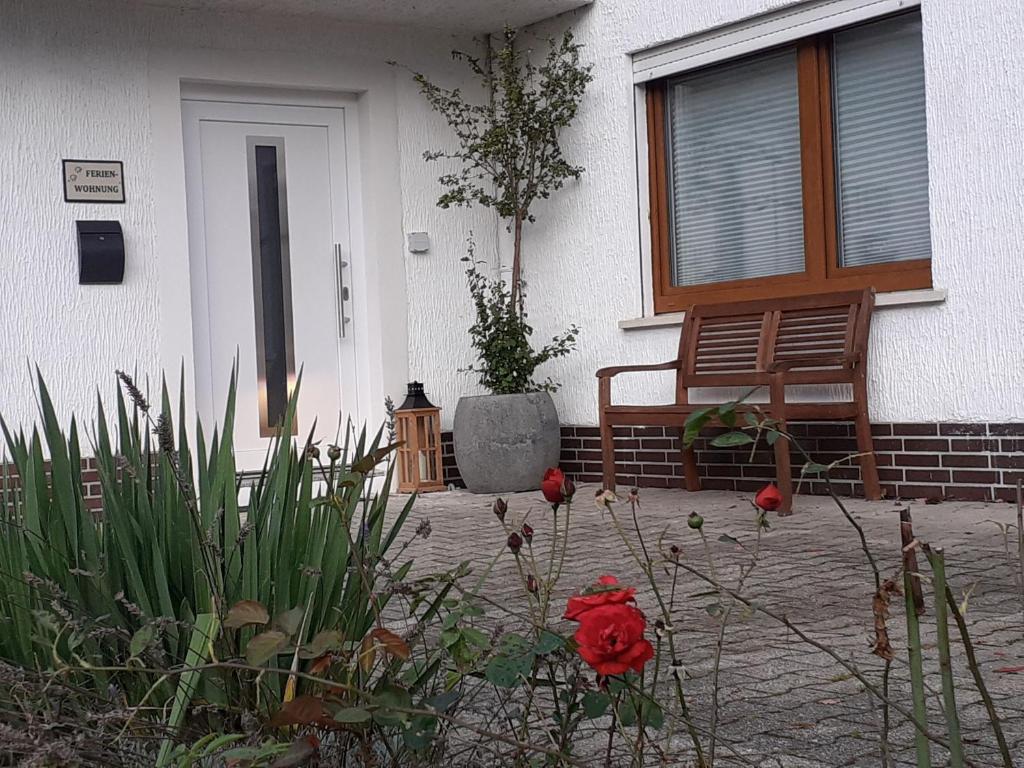 una casa con una panchina e dei fiori davanti di Ferienwohnung am alten Bahndamm a Frielendorf