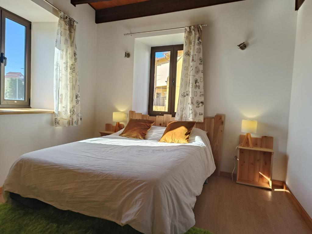 1 dormitorio con 1 cama grande con sábanas blancas y ventana en Casa Agrícola Do Limonete, en Figueira da Foz