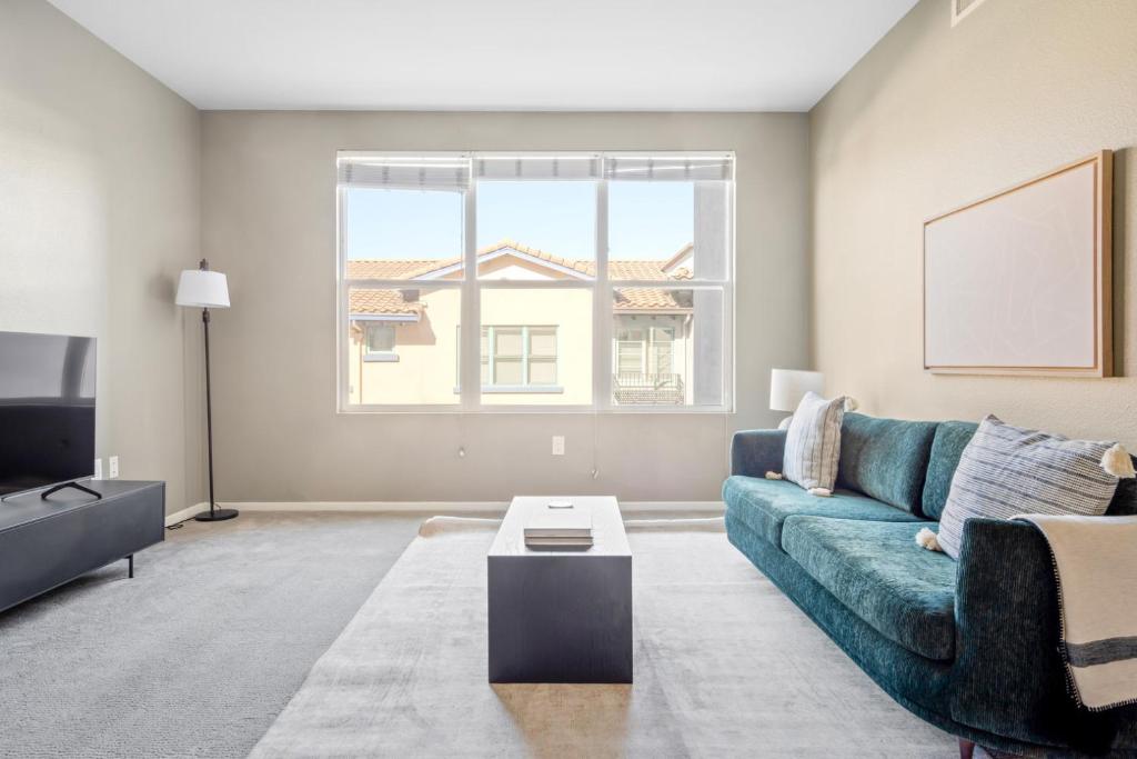 a living room with a blue couch and a tv at Santana Row 2br w gym pool nr highways SFO-1156 in San Jose