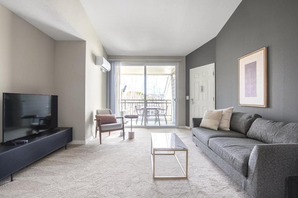 ein Wohnzimmer mit Sofa und Fernseher in der Unterkunft Santa Clara 1BR w Pool Gym nr Caltrain Mall SFO-308 in Santa Clara