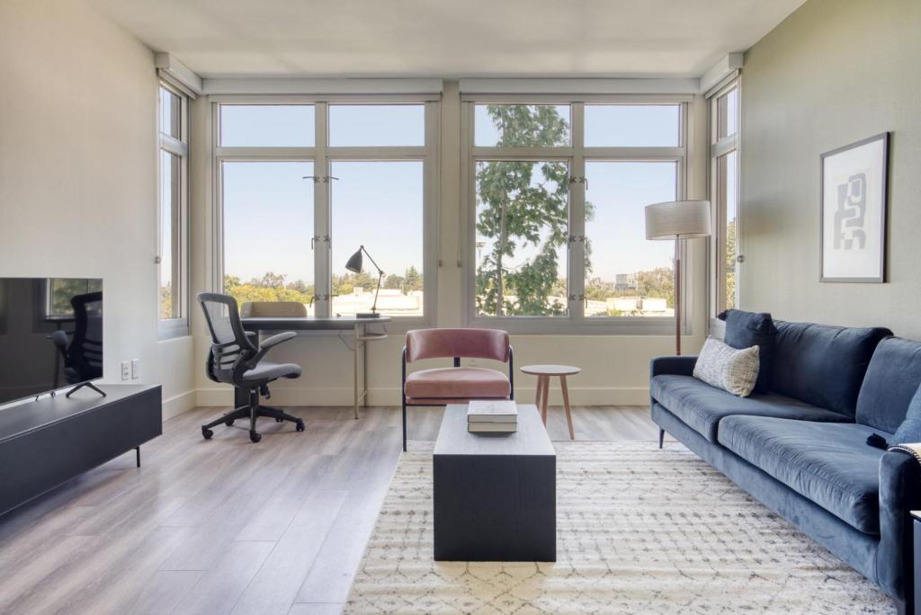 a living room with a blue couch and a desk at Mountain View 2BR w Gym Lounge nr Highways SFO-1080 in Los Altos