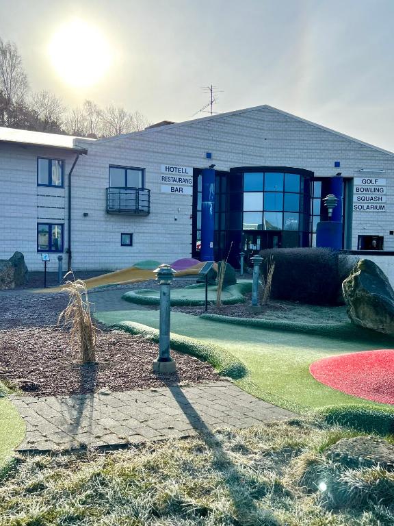 um edifício com um parque infantil em frente em Vandrarhem Nattmössan em Kungsbacka