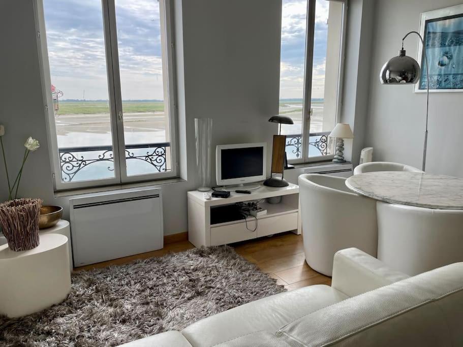 salon z wanną, telewizorem i oknami w obiekcie Appartement familial pour 4 pers et 2 bébés face à la Baie w mieście Saint-Valéry-sur-Somme