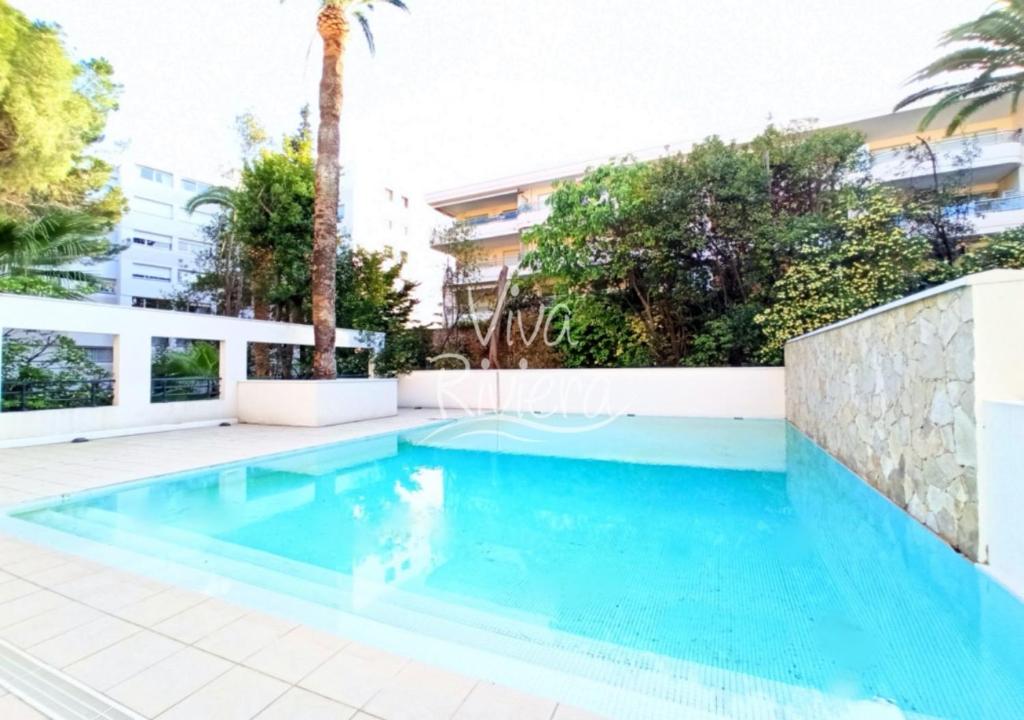 una piscina en una villa con palmeras en Viva Riviera -14 Avenue Isola Bella, en Cannes