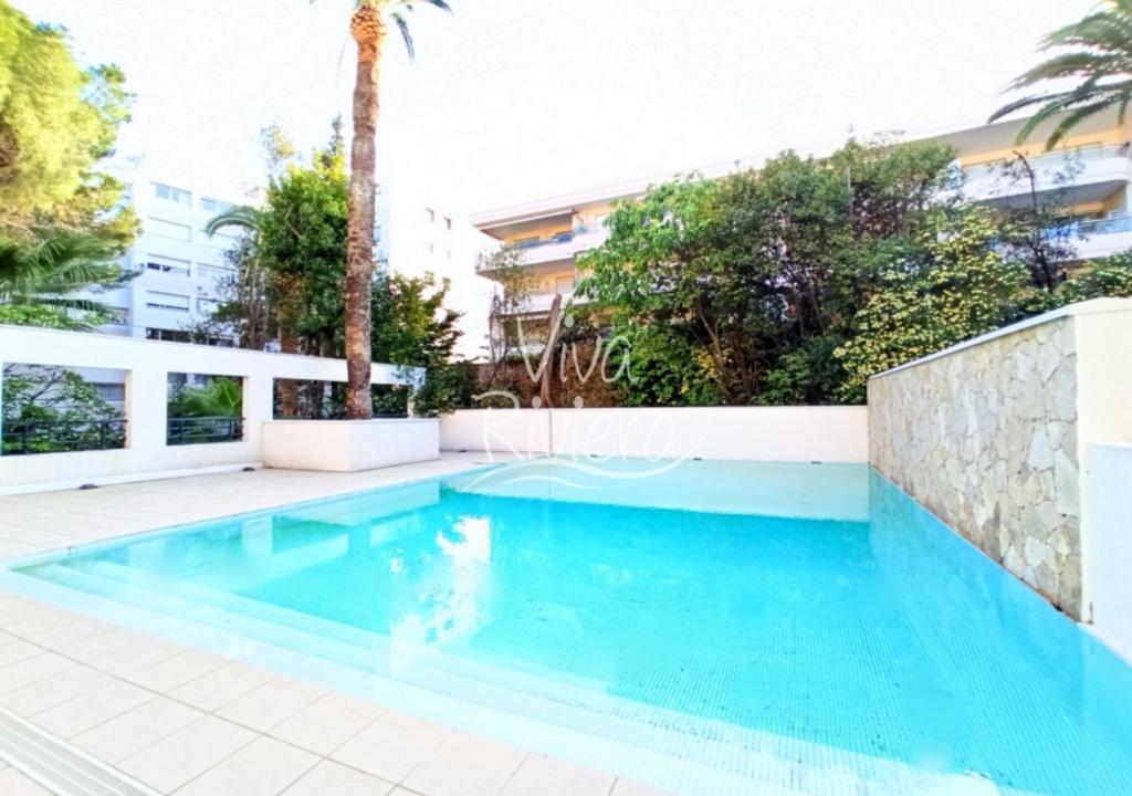 - une piscine dans une villa avec des palmiers dans l'établissement Viva Riviera -14 Avenue Isola Bella, à Cannes
