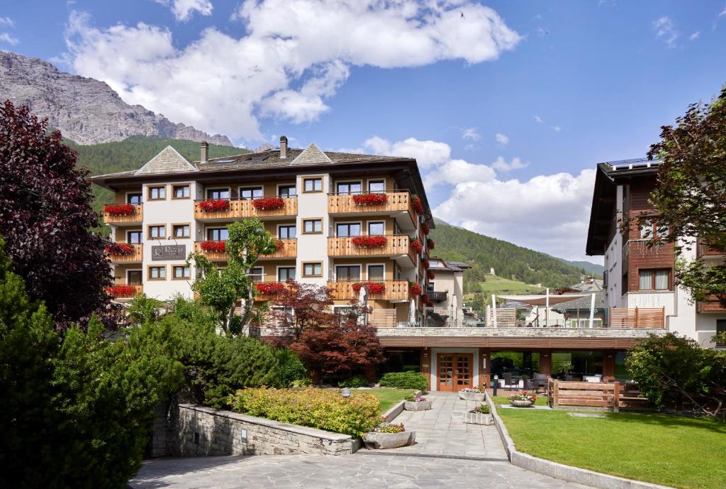 a hotel in the mountains with a garden at Hotel Rezia in Bormio